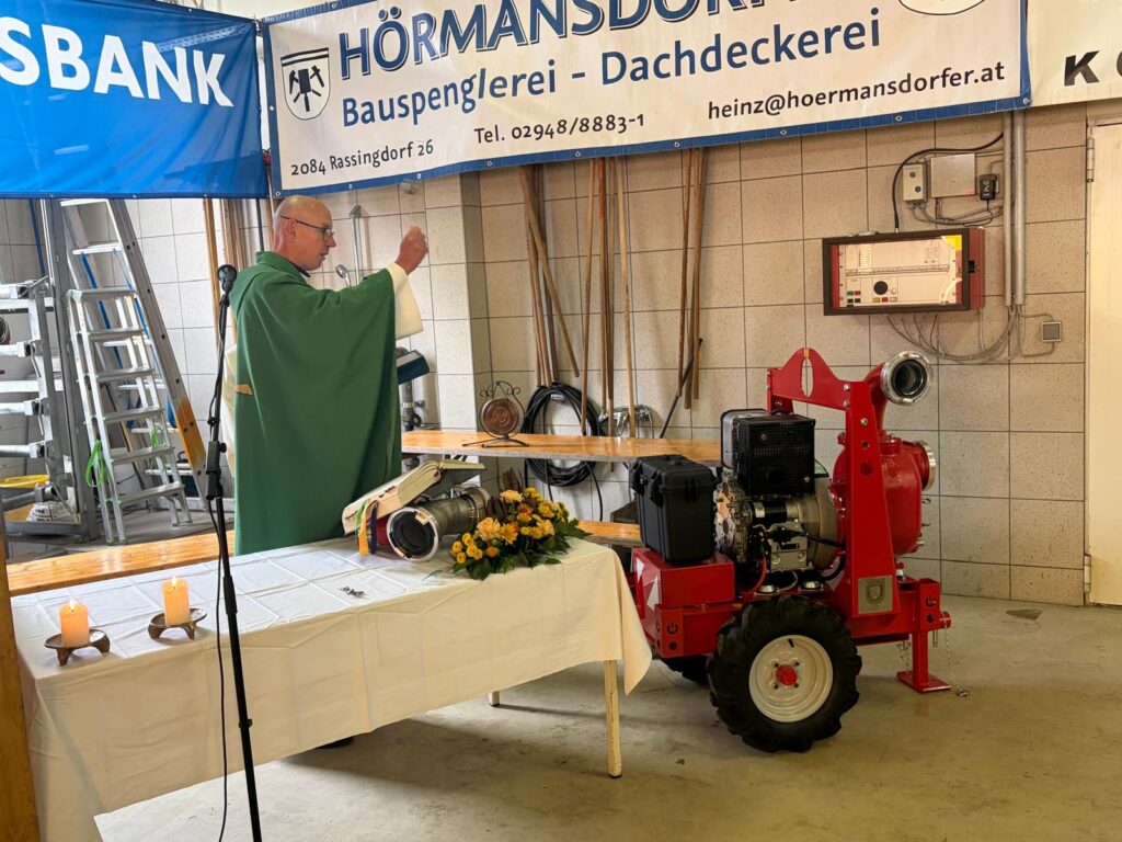 Der örtliche Pfarrer segnet die neu angeschaffte Pumpe SPA 150 der Freiwilligen Feuerwehr Weitersfeld im Rahmen einer Festmesse am 25. Oktober 2026.