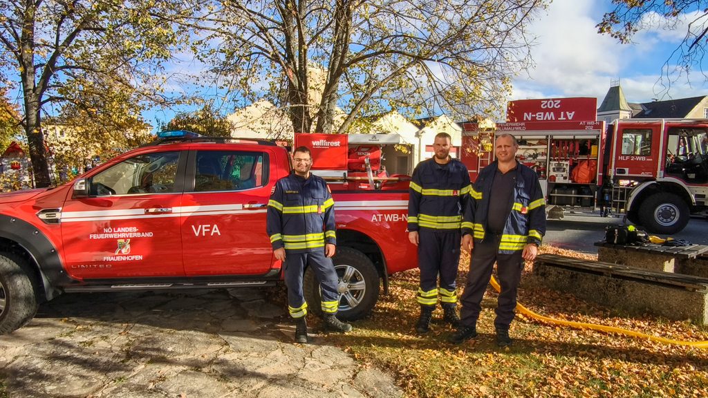 Drei Feuerwehrmitglieder stehen neben dem Waldbrand-Pick-up der Feuerwehr Frauenhofen, der beim Tag der offenen Tür in Horn ausgestellt ist.